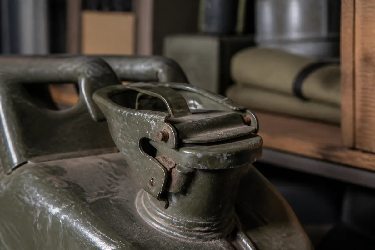 Détail du bouchon à levier et du joint d’un bidon militaire en métal, peinture écaillée